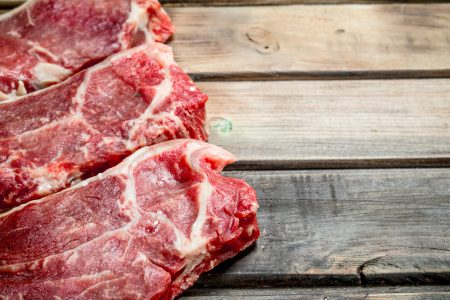 Raw beef steaks . On a wooden background.